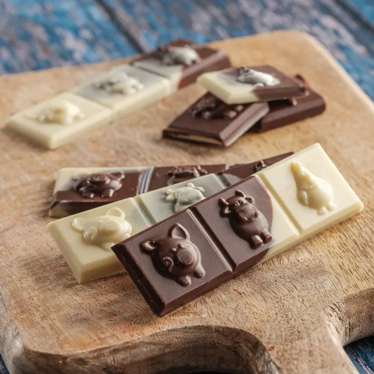 Barre de chocolat au lait et blanc avec trois animaux de la ferme en relief